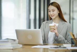 Woman sitting at work on a casual day with coffee. photo