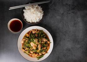 Tasty Stir-fried pork and red hot curry paste with asparagus bean or long bean and  Ingredients are oyster sauce, fish sauce, sugar, kaffir lime leaves in the dish Eat with cooked rice. Thai cuisine photo