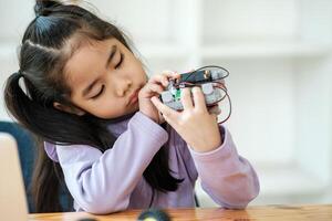 STEM education concept. Asian young girl learning robot design. photo