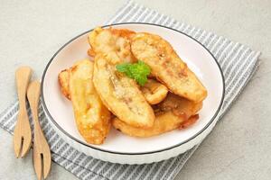 Pisang Goreng Wijen or banana fritters with sesame seed served in white plate. Indonesian food photo