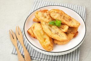 pisang goreng Wijen o plátano buñuelos con sésamo semilla servido en blanco lámina. indonesio comida foto