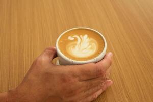 A cup of hot latte coffee on the table for breakfast photo