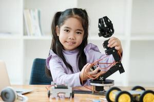 vástago educación concepto. asiático joven niña aprendizaje robot diseño. foto