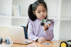 STEM education concept. Asian young girl learning robot design. photo