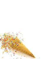 Ice cream in a waffle cone covered with bright sprinkles with space for text photo