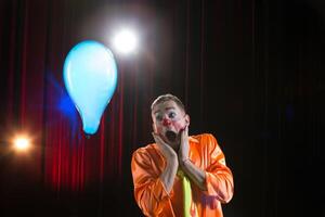 Circus clown performs number. A man in a clown outfit with a toy  A man in a clown outfit with a balloon photo