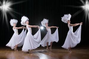 cabaret.chicas danza variedad espectáculo. bailarines en blanco vestidos realizar moderno danza cabaret foto