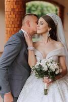 The bride is dressed in an elegant lush white wedding dress with a long veil and is ready for her groom. The first meeting of the bride and groom photo