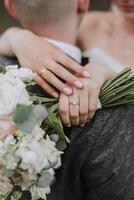 The bride and groom embrace. The bride gently hugs the groom by the shoulders. Beautiful wedding couple. The concept of romance in a newlyweds relationship. Honeymoon. photo