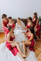 A beautiful bride and her bridesmaids are having fun in the morning. Wedding celebration. Happy girls at their best friend's wedding. A beautiful and elegant bride with her bridesmaids photo