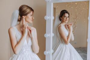 retrato de el novia en el hotel habitación. un hermosa joven niña es vestido en un blanco Boda vestido. moderno Boda peinado. natural constituir. foto