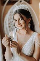 retrato de el novia en el hotel habitación. un hermosa joven niña es vestido en un blanco Boda vestido. moderno Boda peinado. natural constituir. foto