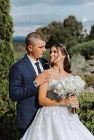 Close-up photo of a wedding couple looking each other in the eyes in nature. The bride and groom look each other in the middle of nature. Tenderness and love in the eyes.