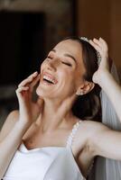 Portrait of the bride in the hotel room. A beautiful young girl is dressed in a white wedding dress. Modern wedding hairstyle. Natural makeup. photo