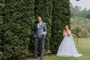 el novia es vestido en un elegante lozano blanco Boda vestir con un largo velo y es Listo para su novio. el primero reunión de el novia y novio foto