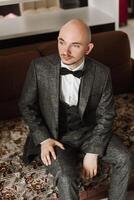 Portrait of a young groom at home before the wedding ceremony. A handsome man dressed in a classic suit. Male portrait. photo