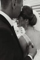 The groom kisses his bride on the temple against the background of beautiful nature on a summer day. Art. Selective focus. photo