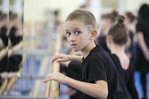 Belarus, Gomel, July 4, 2018. Indicative training circus school.The little boy at the ballet machine.Boy in ballet school photo