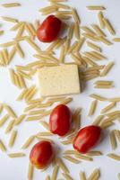 Tomatoes a piece of cheese pasta on a white background close-up photo