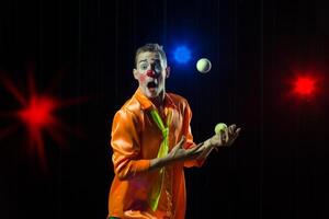 Circus clown performs number. Clown man juggles photo