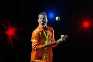 Circus clown performs number. Clown man juggles photo