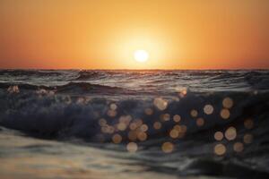 Beautiful sunset over the sea. Red sun and waves. photo