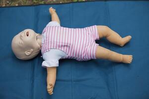 Mannequin child for first aid training. Training dummy kid for practicing artificial respiration photo