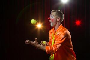 Circus clown performs number. Clown man juggles photo
