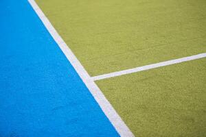 Sports grass green and blue with a white stripe.Sports field background photo