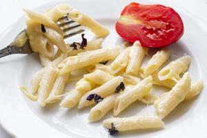 Pasta with cheese and tomato on a plate. Italian lunch photo