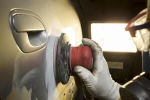 Hands grind polish the car. Car body repair photo