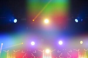 Bright festive multi-colored stage lighting with optical flare and rays from lighting lamps. photo