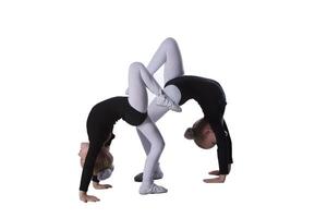 Girls gymnasts on a white background. Two little acrobats perform a number photo