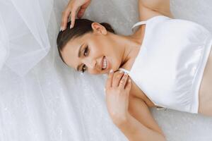 A beautiful young bride girl is lying in a beautiful robe. Morning of the bride before the wedding ceremony. photo