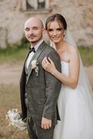 el novia y novio abarcar. el novia suavemente abrazos el novio por el espalda. hermosa Boda Pareja. el concepto de romance en un recién casados relación. Luna de miel. foto