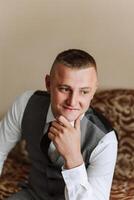 retrato de un joven novio a hogar antes de el Boda ceremonia. un hermoso hombre vestido en un clásico traje. masculino retrato. foto