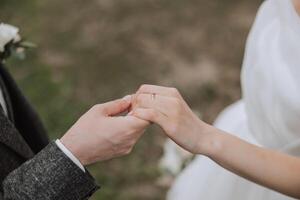 novio participación de la novia mano, recortado foto. detalles a el boda. oro Boda anillos en manos. alto calidad foto. foto