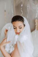 Beautiful bride in a dressing gown in the morning before the wedding ceremony. Incredible hairstyle of the bride. Natural and modern makeup. Portrait of a young bride in a dressing gown. photo