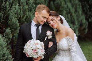 The bride is dressed in an elegant lush white wedding dress with a long veil and is ready for her groom. The first meeting of the bride and groom photo