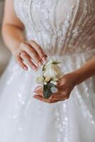 Boda flor en el ojal de flores en el manos de el novia. Boda detalles. el primero reunión de el novia y novio. el novia es esperando para el novio. foto