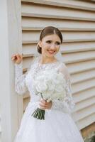 Beautiful bride with wedding flowers bouquet, attractive woman in wedding dress. Happy newlywed woman. Bride with wedding makeup and hairstyle. Smiling bride. Wedding day. Gorgeous bride. Marriage. photo