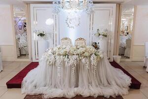 Restaurant wedding table for bride and groom. luxury wedding table with beautiful flowers. pink stylized photo