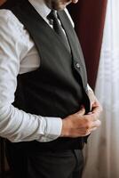 portrait of a man with a beard in a classic suit. The groom is preparing for the wedding. The man is wearing a white shirt and a suit. Stylish groom photo