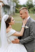 Close-up photo of a wedding couple looking each other in the eyes in nature. The bride and groom look each other in the middle of nature. Tenderness and love in the eyes.