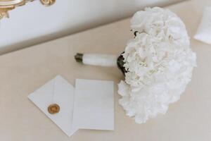 Boda ramo. blanco cortar rosas, verde semilla cabezas y hojas. verde tallos y blanco cinta y oro Boda anillos foto