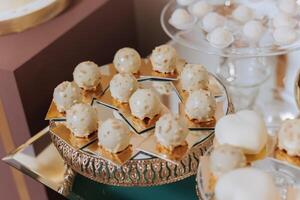 Candy bar at a wedding. Delicious desserts. Beautiful decorations. Fruits. Sweet cakes on your holiday. Birthday. Sweet life. photo