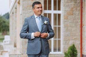 retrato de el novio en naturaleza en el verano. elegante alto novio en un elegante azul negocio traje. empresario en naturaleza. retrato de un exitoso hombre. Boda retrato de el novio. foto