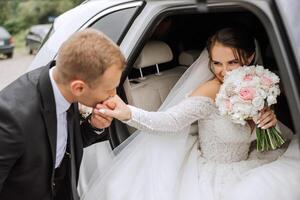 The bride looks out of the car window. Close-up portrait of a pretty shy bride in a car window. Bride smile emotions photo