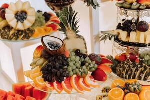 Fruit buffet for a wedding. Assortment of exotic fruits in the restaurant. Various compositions from fresh fruits. photo