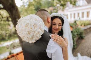 el novia es vestido en un elegante lozano blanco Boda vestir con un largo velo y es Listo para su novio. el primero reunión de el novia y novio foto